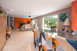 a dining room and living room with a table and chairs at Villa - Piscine, jacuzzi, sauna in Plouharnel