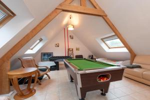 a attic living room with a pool table at Villa - Piscine, jacuzzi, sauna in Plouharnel