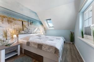 a bedroom with a bed and a painting of a beach at Feriendoppelhaus Frühling in Stakendorf