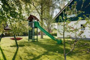 a playground with a green slide in a yard at Feriendoppelhaus Frühling in Stakendorf