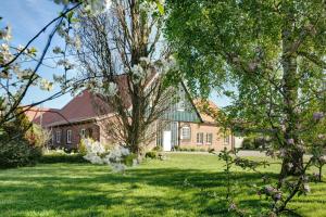 a brick house with a tree in the yard at Feriendoppelhaus Frühling in Stakendorf