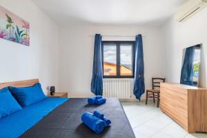 a bedroom with a bed with blue pillows on it at Casa Cuccureddu in Jerzu