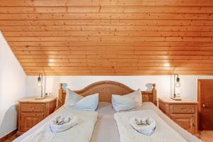 two beds in a bedroom with a wooden ceiling at Vogtadeshof in Wolfach +145 photos