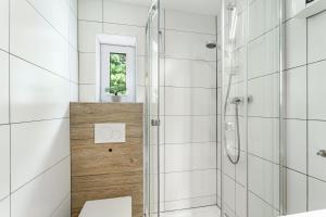 a white bathroom with a shower and a toilet at Perle am Pön in Medebach +30 photos
