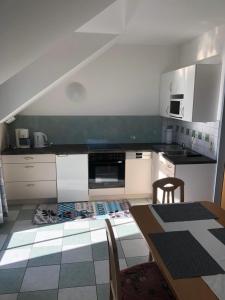 a kitchen with white cabinets and a table with chairs at Appartment Isabelle Sky in Lake Pressegg