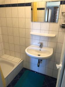 a white bathroom with a sink and a bath tub at Appartment Isabelle Sky in Lake Pressegg