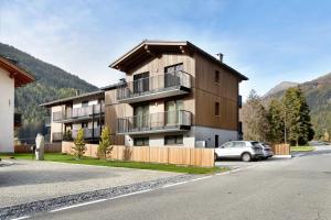 a apartment building with a car parked in front of it at Violet a due passi da Bormio in Valdidentro