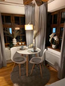 a white table and chairs in a room with windows at Ulmer Spatzennest in Ulm