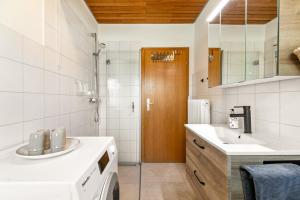 a bathroom with a sink and a washing machine at Dörpshus in Rehm-Flehde-Bargen +16 photos