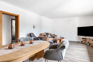 a living room with a table and chairs and a tv at Dörpshus in Rehm-Flehde-Bargen