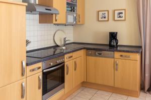 a kitchen with wooden cabinets and a sink at Ferienwohung Traumgarten in Obereisenheim