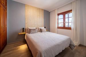 a bedroom with a white bed with a window at Callao in Playa Honda