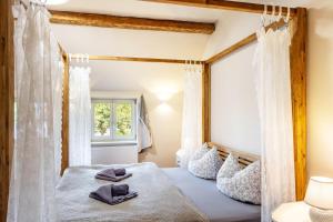 a bedroom with a bed with white curtains at Hof Rosenstein in Helle