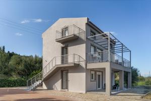 a white building with stairs on the side of it at Euphoria Apartments in Lixouri