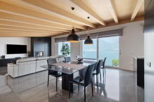 a dining room with a table and chairs and a couch at Luxury Lakefront Penthouse in Lezzeno