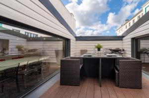 a patio with a table and chairs on a deck at Beau Loft Lorient - centre ville in Lorient