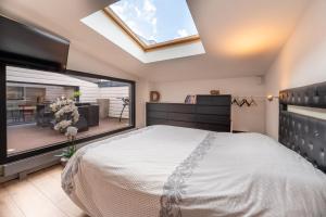 a bedroom with a large bed and a large window at Beau Loft Lorient - centre ville in Lorient