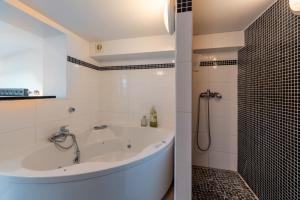 a white bathroom with a tub and a shower at Beau Loft Lorient - centre ville in Lorient