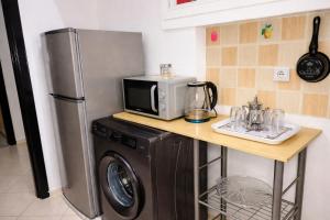 a kitchen with a microwave and a washing machine at Spacious 2BR Apartment with Moroccan Salon near Aquaparc Tamaris Casablanca in Casablanca