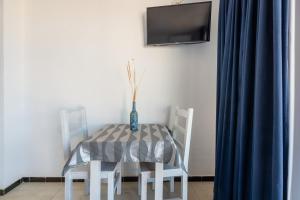 a dining room table and chairs with a vase on it at Estudio Mirada 309 in Es Pujols