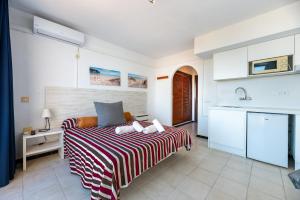 a bedroom with a bed with a striped blanket at Estudio Mirada 309 in Es Pujols