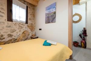 a bedroom with a yellow bed and a window at Sierra De Majalinos in Ejulve