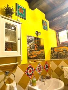 a yellow bathroom with a sink and a window at Loureiro in Vega de Logares +34 photos