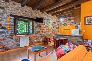 a living room with a stone wall at Loureiro in Vega de Logares
