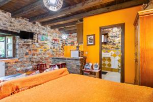a bedroom with a bed and a stone wall at Loureiro in Vega de Logares