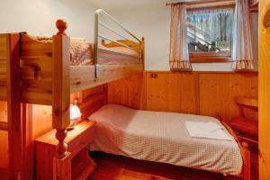 a bedroom with two bunk beds and a window at Appartamenti Marmolada Falcade in Falcade
