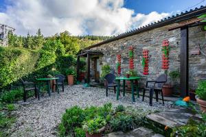 a patio with tables and chairs in a garden at Loureiro in Vega de Logares