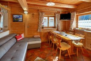 a living room with a couch and a table in a cabin at Appartamenti Marmolada Falcade in Falcade