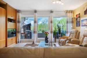 a living room with a couch and a large window at Apartment Seeadler in Butjadingen