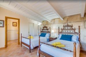 ein Schlafzimmer mit zwei Betten und blauen und gelben Kissen in der Unterkunft Son Vanrell in Campos + 22 Fotos