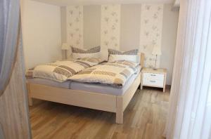 a bedroom with a bed and a table with a night stand at Ferienwohnung Landidyll in Enzklösterle