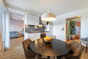 a kitchen and dining room with a table and chairs at Appartement Annie in Nova Ponente