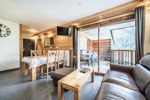 a living room with a couch and a table at Les loges blanches204 centre chatel in Châtel