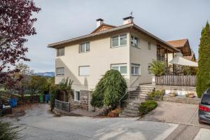 a large white house with a tree in front of it at Appartement Annie in Nova Ponente