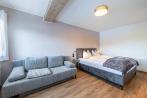 a bedroom with a bed and a couch at Appartement Annie in Nova Ponente