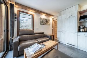 a living room with a couch and a table at Les loges blanches204 centre chatel in Châtel +13 photos