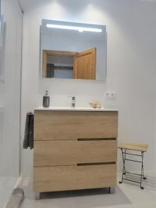 a bathroom with a wooden sink and a mirror at Angy Apartment in Alcudia +17 photos