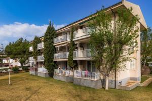an apartment building with balconies and trees at Angy Apartment in Alcudia