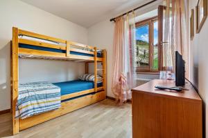 a bedroom with bunk beds and a desk with a computer at Appartamento Collini Le Betulle in Spiazzo