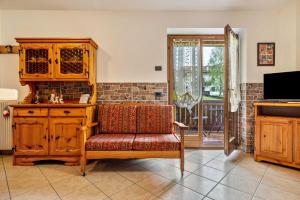 a living room with a chair and a wooden cabinet at Appartamento Collini Le Betulle in Spiazzo