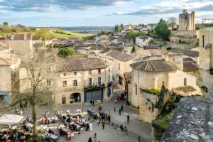 a group of people walking around a town with buildings at Sur La Route Des Vins - Libourne in Libourne