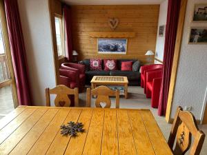 a living room with a table and a couch at Duplex Méribel Mottaret 8 personnes in Les Allues
