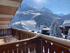 a balcony with a view of a snow covered mountain at Duplex Méribel Mottaret 8 personnes in Les Allues
