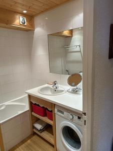 a bathroom with a washing machine and a sink at Duplex Méribel Mottaret 8 personnes in Les Allues