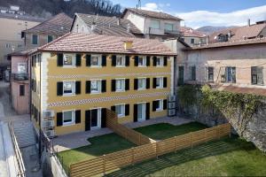 a yellow house with a fence in a city at Ca' Vittorio in Rossiglione
