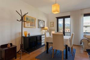 a dining room with a table and chairs and a room with a window at Appartamento Moser P in Levico Terme